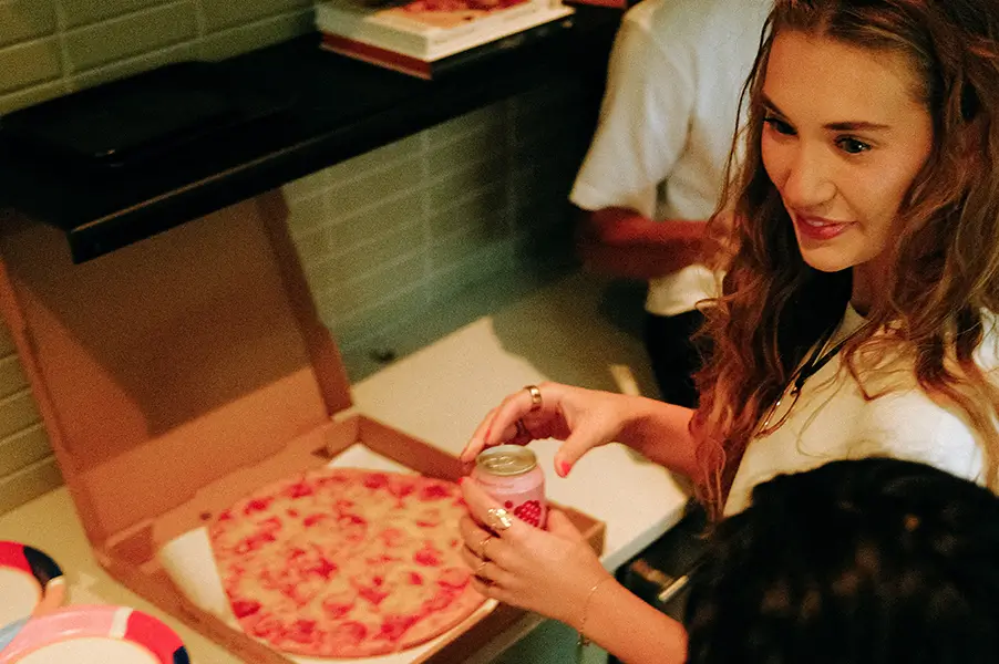 a woman next to a pizza box